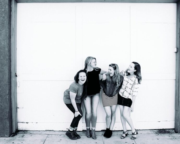 grayscale photography of four women wearing clothes