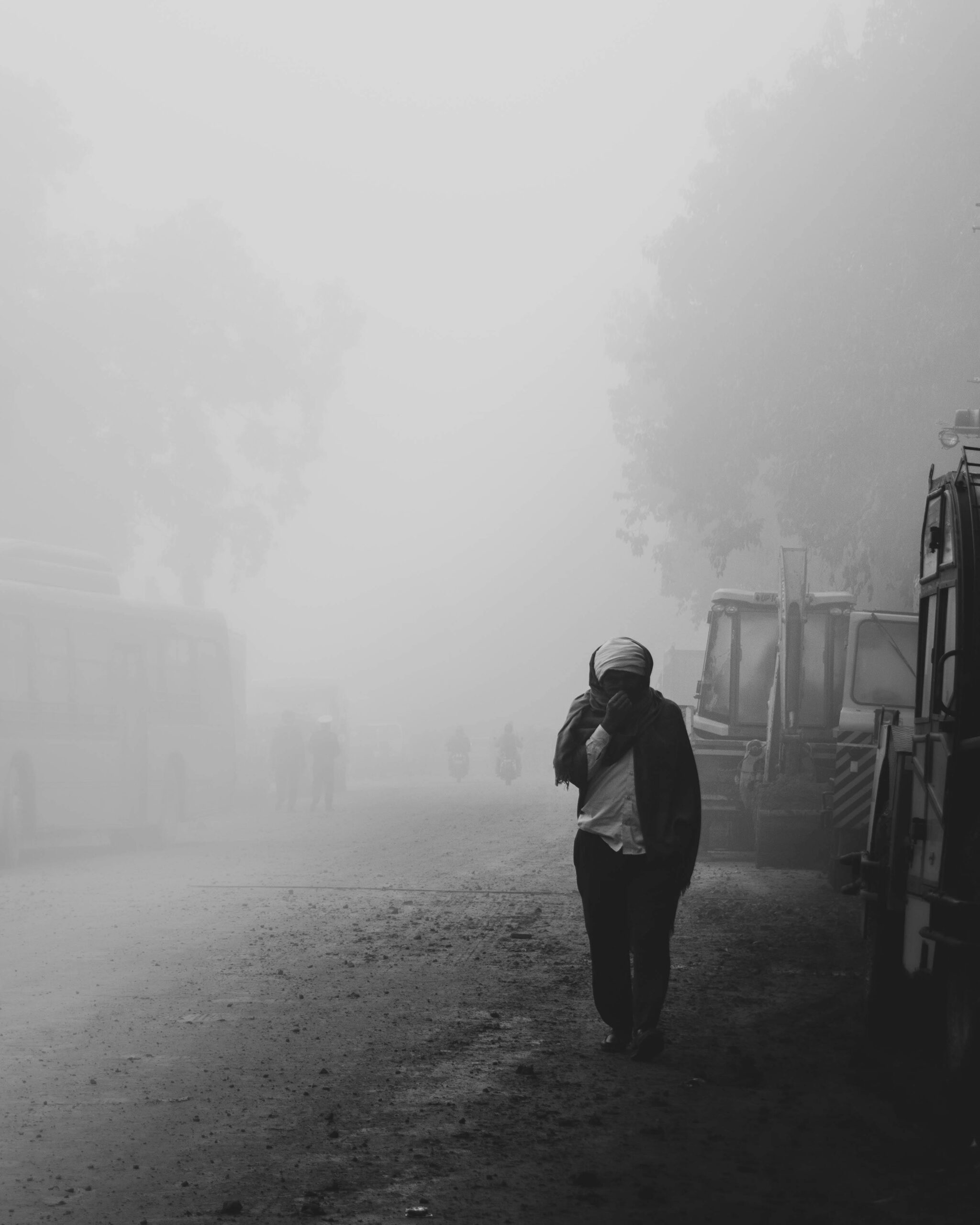 Thick smog engulfing Delhi, obscuring visibility and shrouding buildings and vehicles, highlighting severe air pollution and poor air quality conditions